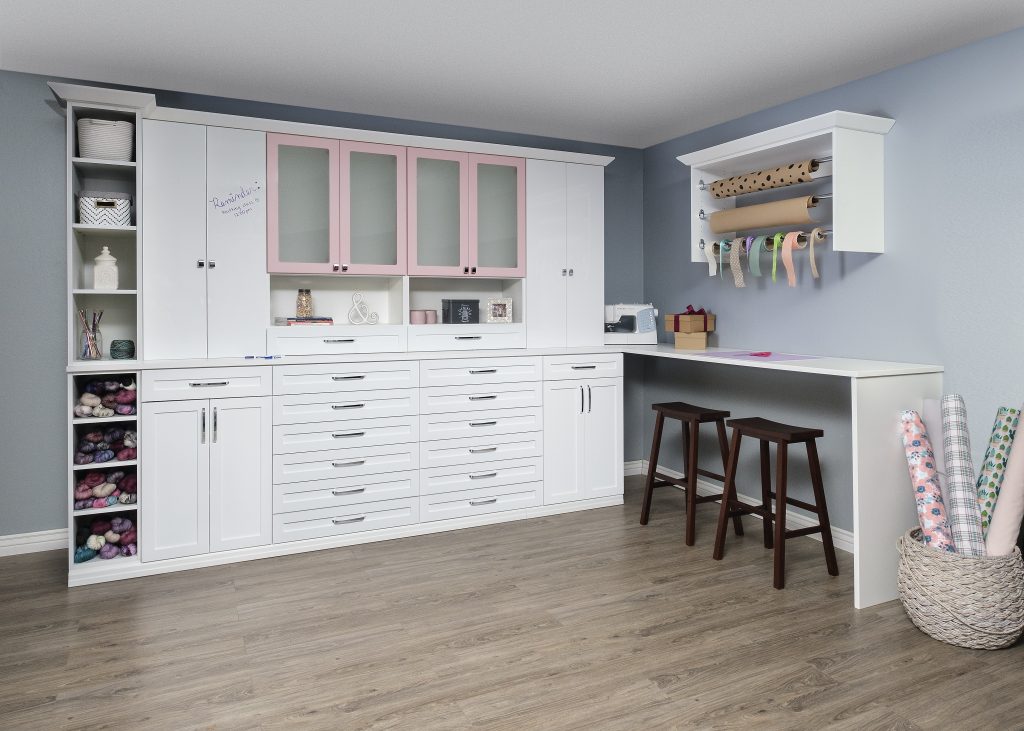 White and blush cabinet installation in a craft room.